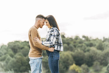 Smiling girlfriend and boyfriend touching their foreheads together - DAMF00760