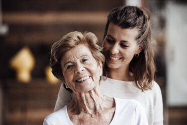 Lächelnde junge Frau schaut auf glückliche Großmutter - GUSF05529