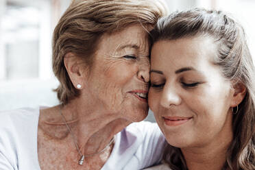 Affectionate grandmother with granddaughter at home - GUSF05550