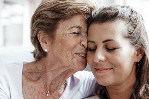 Affectionate grandmother with granddaughter at home - GUSF05550