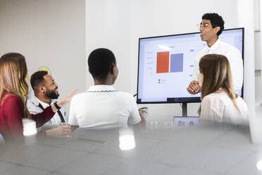 Ein Team diskutiert während der Arbeit in einer Besprechung im Büro - PNAF01084