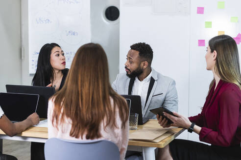 Geschäftsleute diskutieren bei der Arbeit in einer Besprechung - PNAF01087