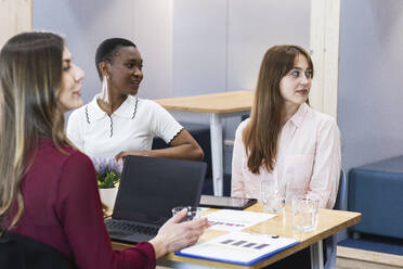 Female entrepreneurs looking away in meeting at office - PNAF01098