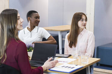 Unternehmerinnen schauen bei einer Besprechung im Büro weg - PNAF01098