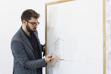 Young businessman drawing diagram on whiteboard - PNAF01126