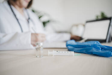 Senior female doctor and medical equipment on desk - EBBF02797