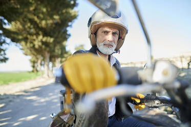 Älterer Mann auf dem Fahrrad sitzend während einer Autofahrt - KIJF03672