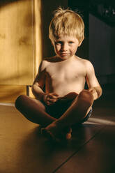 Boy sitting on floor at home - MFF07674