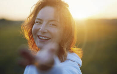 Smiling redhead woman enjoying during sunset - AZF00210