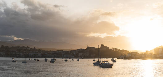 Spain, Cantabria, San Vicente de la Barquera, Boats in sea at sunset - JAQF00406