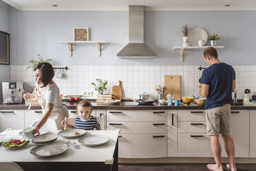 Father and mother with cute son preparing food in kitchen - VYF00434
