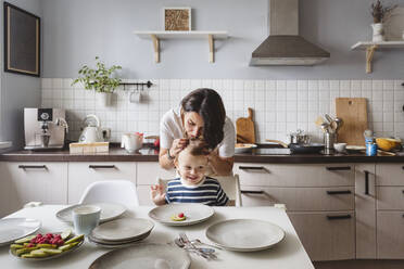 Mutter mit verspieltem Sohn in der Küche zu Hause - VYF00435