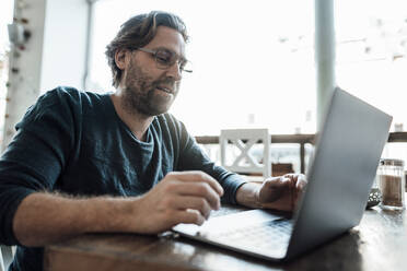 Mann benutzt Laptop in einem Kaffeehaus - JOSEF03951