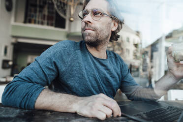 Mann mit Laptop und Kaffeetasse im Cafe - JOSEF03955