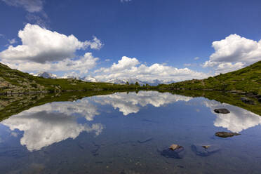 Wolken spiegeln sich in einem kleinen glänzenden See im Speikboden-Massiv - LOMF01274