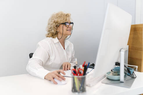 Smiling receptionist using computer at dentist's office - EGAF02137