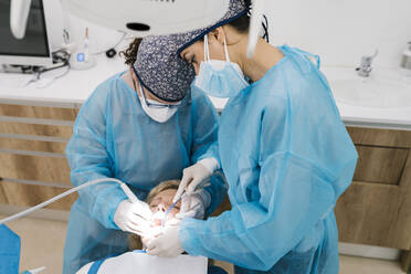 Female orthodontists giving treatment to patient in clinic - EGAF02152