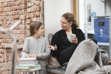 Businesswoman talking with daughter while studying at home - DHEF00608