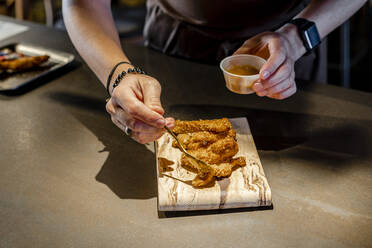 Chef pouring sauce on food in restaurant - DLTSF01710