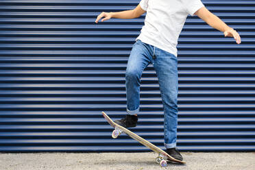 Junger Mann übt Stunt auf dem Skateboard - AODF00366