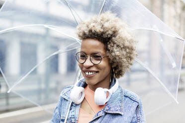 Lächelnde Frau mit Brille und Regenschirm - RFTF00036