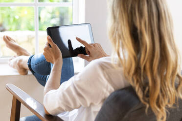Blond woman using digital tablet at home - SBOF03395