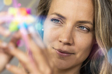 Schöne Frau mit blauen Augen schaut auf fluoreszierendes Objekt - SBOF03435
