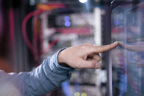 Male IT expertise touching computer screen in server room - FKF04151