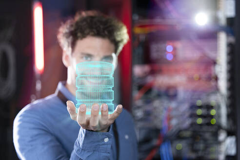 Digitales zusammengesetztes Bild eines männlichen IT-Spezialisten, der eine Datenbank im Serverraum hält - FKF04152