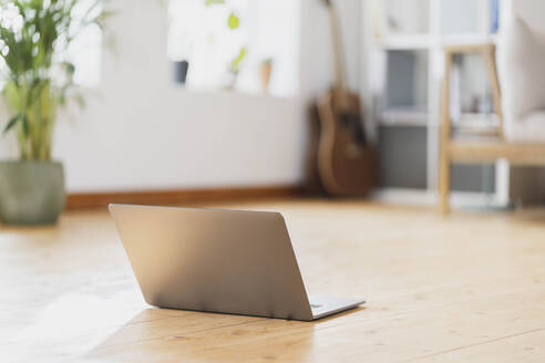 Laptop auf dem Boden im Wohnzimmer - SBOF03549