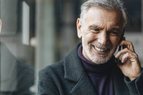 Smiling mature man talking on mobile phone - DGOF02011