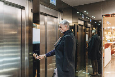 Modischer Geschäftsmann benutzt Aufzug im Hotel - DGOF02036