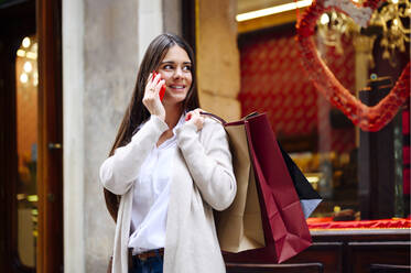 Woman talking on mobile phone while looking away - PGF00481