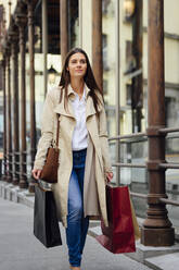 Frau geht beim Einkaufen in der Stadt auf dem Gehweg - PGF00493