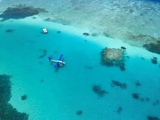Luftaufnahme eines Wasserflugzeugs, das im türkisfarbenen Wasser des Male-Atolls schwimmt - KNTF06187