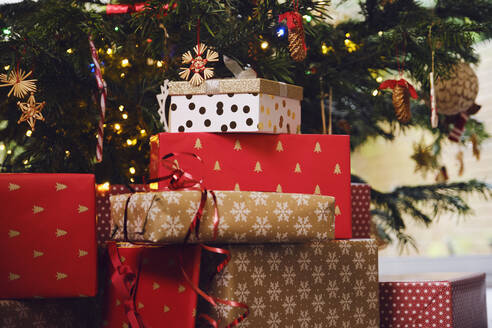 Stapel von Geschenken vor dem Weihnachtsbaum zu Hause - PWF00280