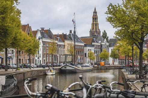 Niederlande, Groningen, Stadtkanal mit einer Reihe von Stadthäusern im Hintergrund - KEBF01833