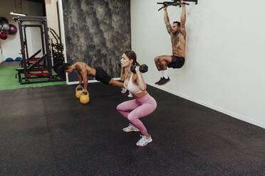 Sportler beim Training mit Geräten im Fitnessstudio - EBBF02822