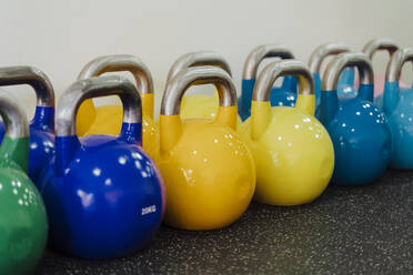 Mehrfarbige Kettlebell in einer Reihe im Fitnessstudio - EBBF02826