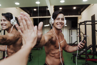 Sportler grüßt mit High-Five mit Freund im Fitnessstudio - EBBF02887