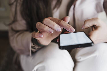 Hands of woman using smart phone at home - EBBF02914