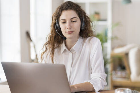 Schöne weibliche Kundenbetreuerin mit Laptop im Home Office - SBOF03604