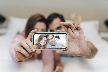 Pärchen macht Selfie mit Handy im Hotel - DGOF02066