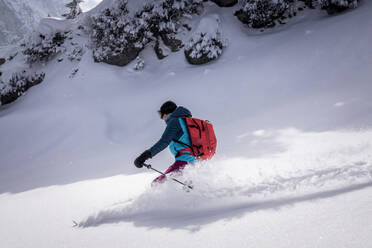 Frau in warmer Kleidung beim Skifahren auf Schnee im Winter - MALF00344