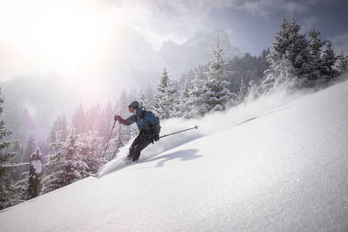 Mann, der beim Skifahren im Winter von einem verschneiten Berg absteigt - MALF00346