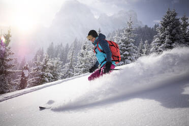 Skifahrerin auf einem verschneiten Berg an einem sonnigen Tag - MALF00347