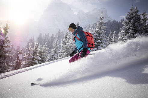 Skifahrerin auf einem verschneiten Berg an einem sonnigen Tag - MALF00347