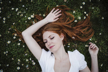 Beautiful woman with eyes closed lying on grass - EBBF02924