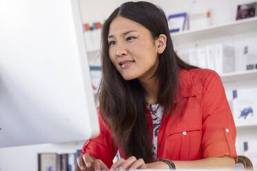 Junge Frau arbeitet am Computer in einer Bibliothek - BMOF00520