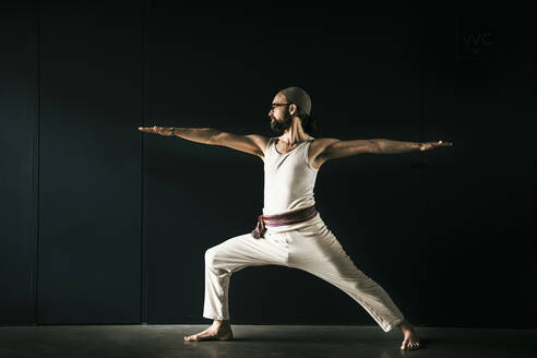 Männlicher Yogalehrer beim Üben mit ausgestreckten Armen - MJRF00375